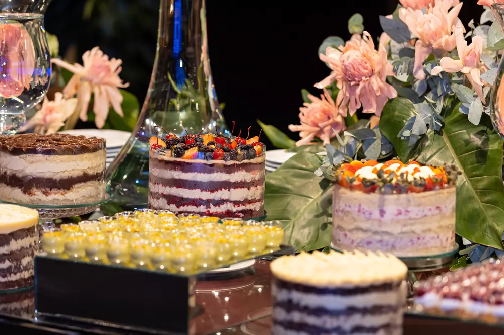 Mesa de bolos e doces decorada com flores