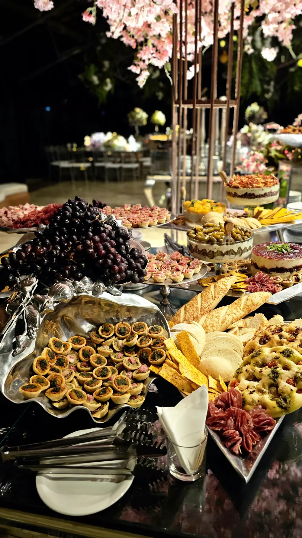 Mesa de buffet montada com frios, tortas e canapés