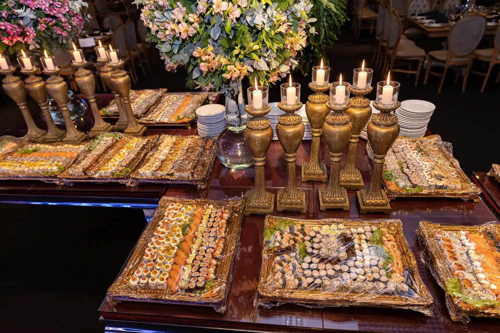 Mesa de salgados com castiçais dourados
