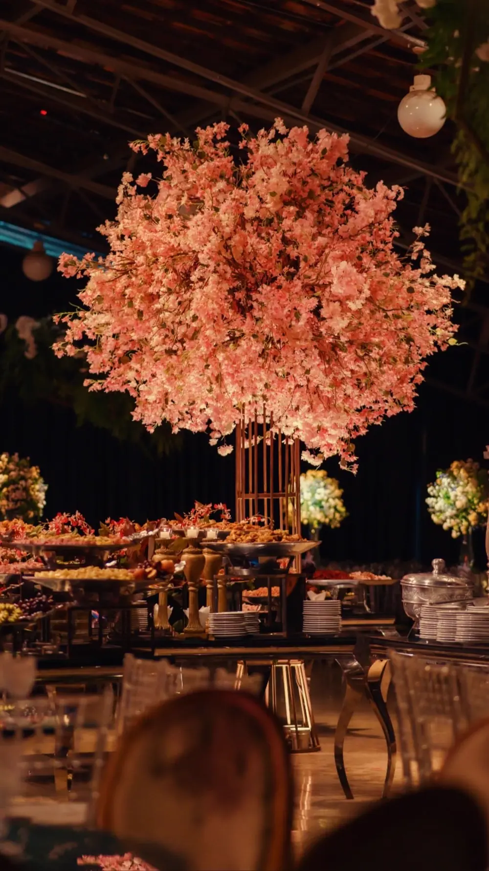 Árvore de flores rosa sobre a mesa do buffet