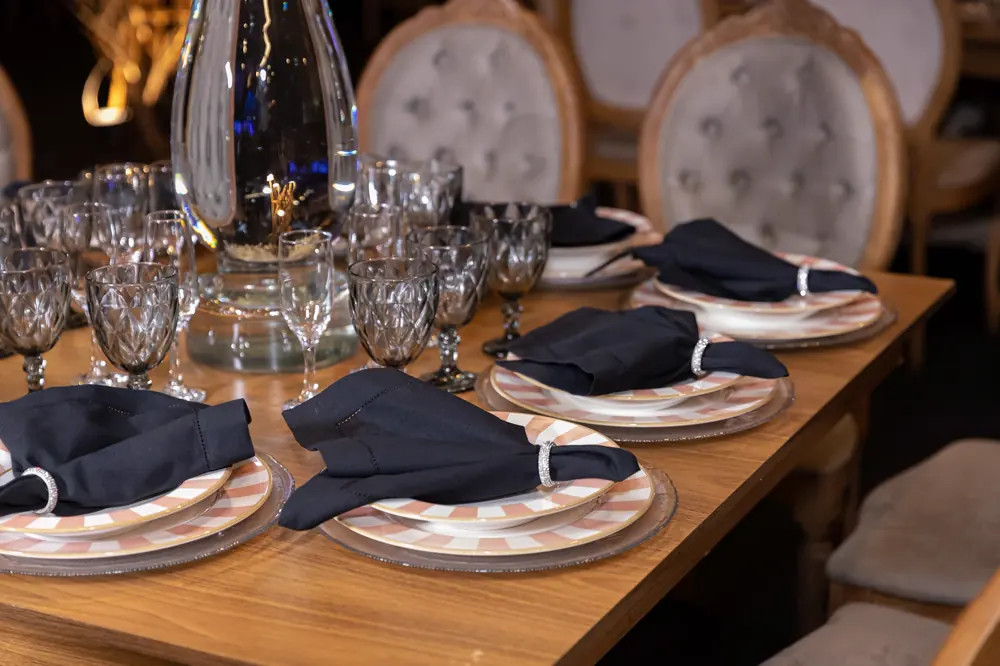 Detalhe da mesa posta com guardanapos e cristais